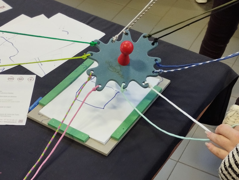 crayon coopératif tenu par 12 ficelles